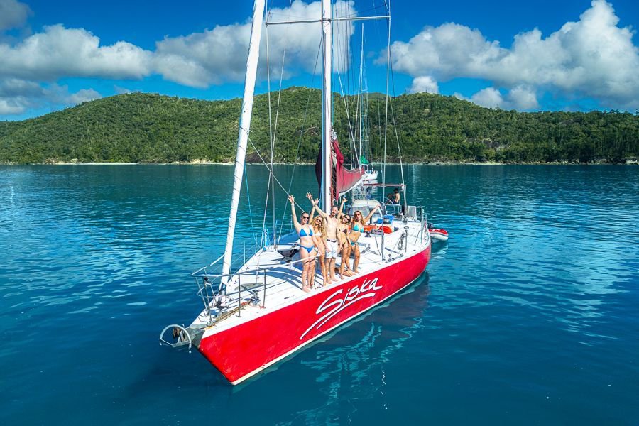 Guests smiling at the bow of Siska in swimwear