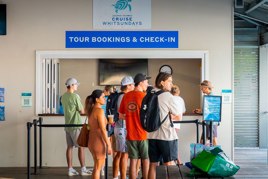 Guests lining up at the Cruise Whitsundays tour bookings and check-in counter inside the terminal before departing for island and reef tours