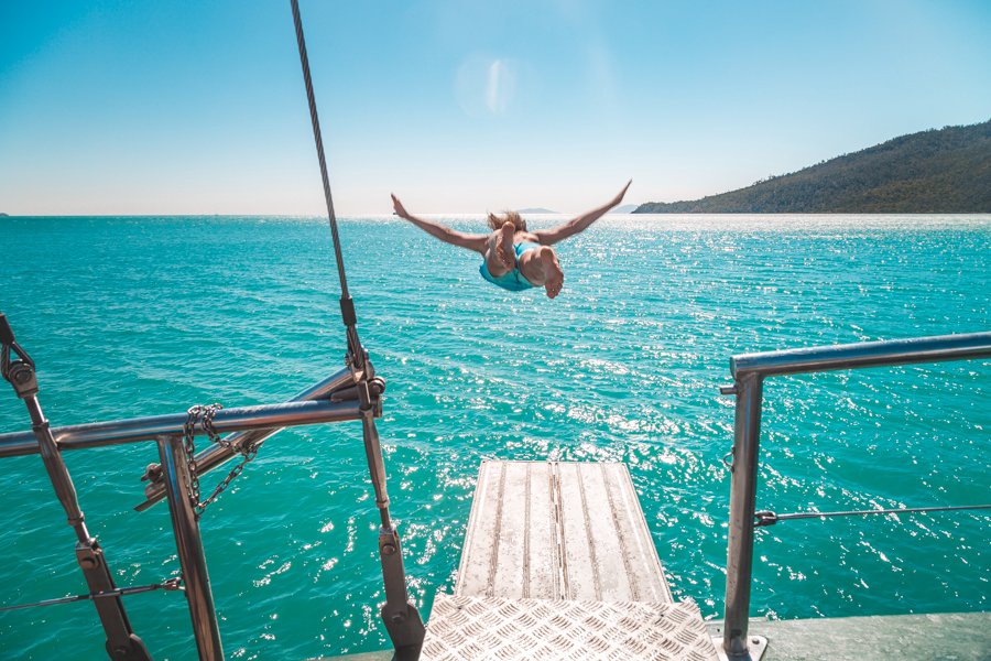 Guest jumping into the turquoise waters from New Horizon in the Whitsundays