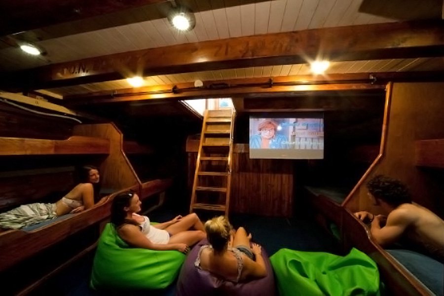 Guests relaxing in the lounge area watching a movie onboard New Horizon