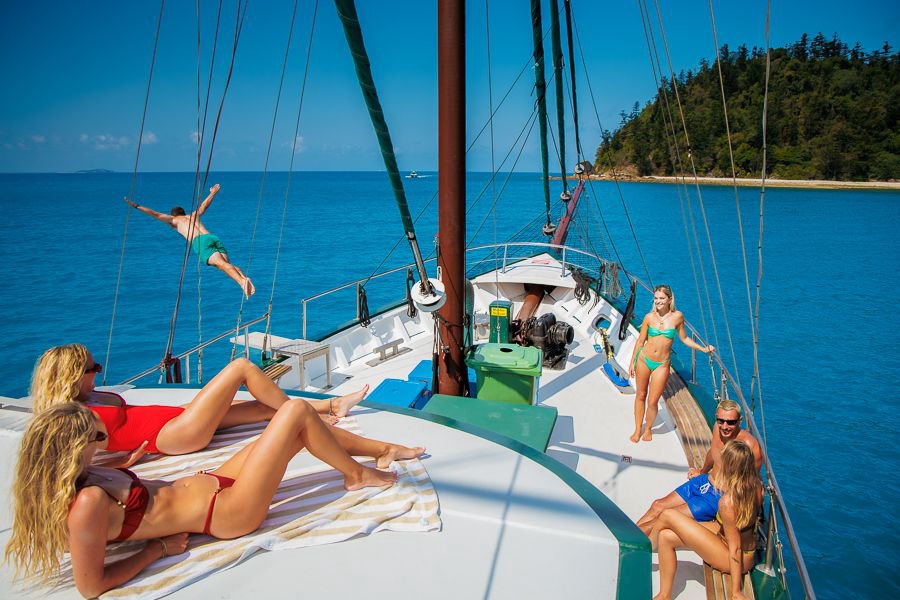 Guests relaxing on deck and jumping into the water off New Horizon in the Whitsundays