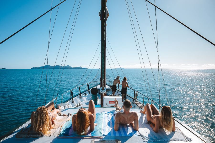Guests relaxing on deck while sailing through the Whitsundays