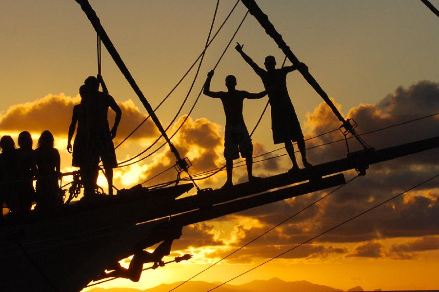 Guests silhouetted on the bow of New Horizon at sunset in the Whitsundays