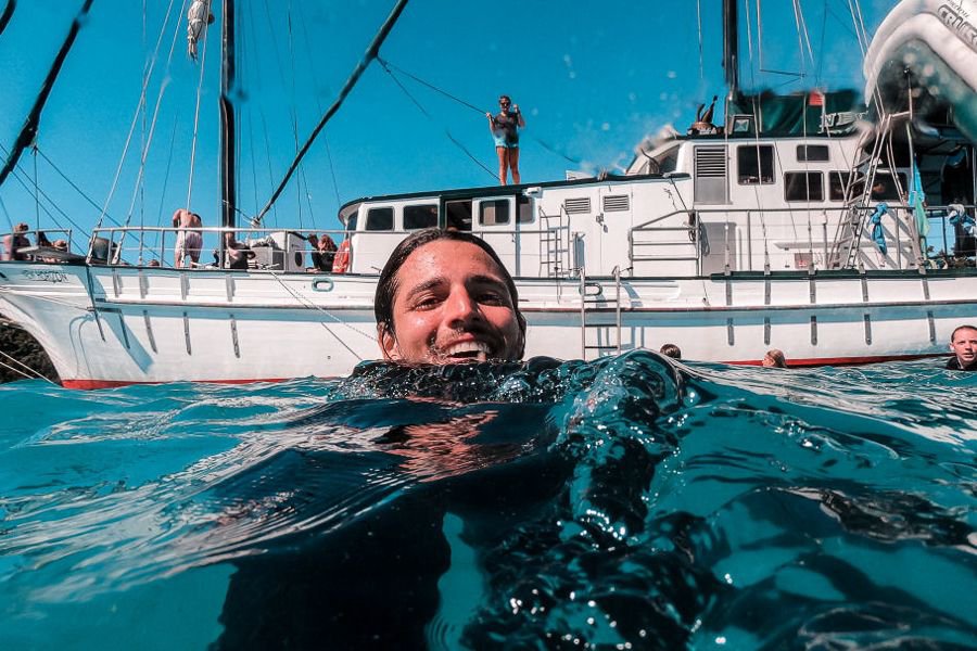 Guest swimming in the ocean beside New Horizon in the Whitsundays