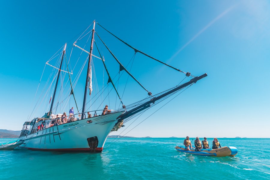 Guests riding in a tender boat beside New Horizon in the Whitsundays