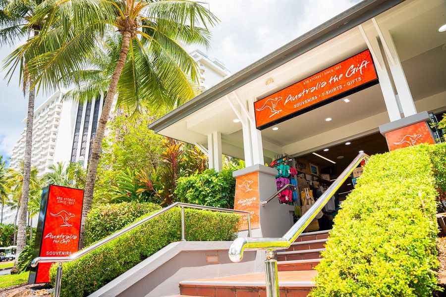 Entrance to Australia The Gift souvenir shop in Airlie Beach surrounded by palm trees and tropical greenery