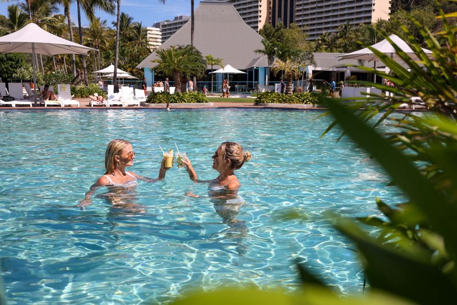 Guests relaxing with drinks in a tropical resort pool in the Whitsundays
