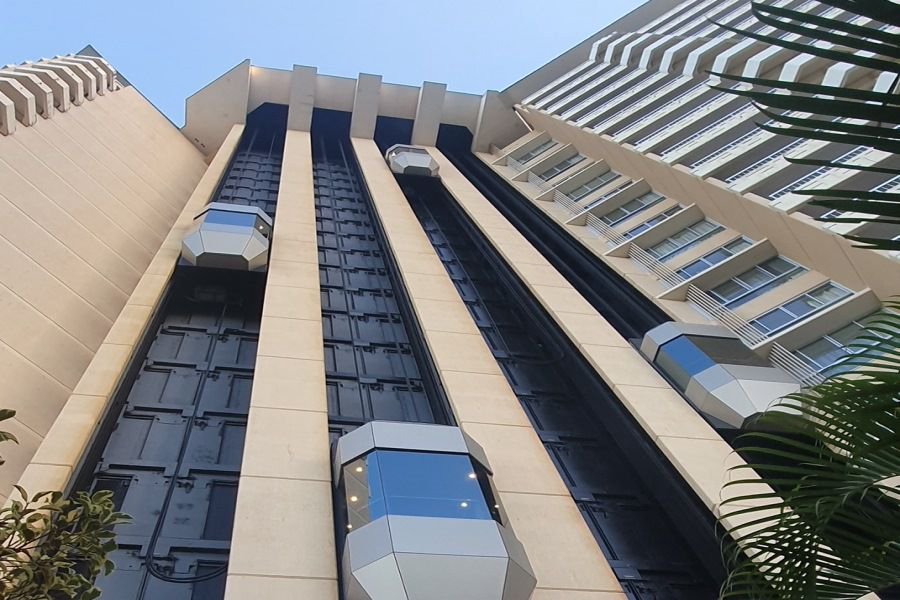 Upward view of a tall resort building with exterior glass elevators in Hamilton Island