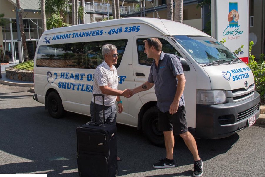 Guest being greeted by a Heart of Reef Shuttles driver for airport transfer in the Whitsundays