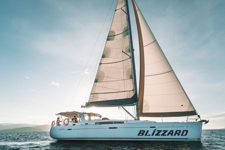 Blizzard Sailing through the Whitsunday Islands with sails extended at sunset