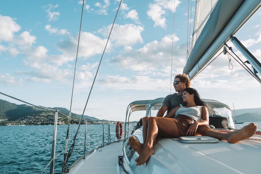 couple lounging on the deck of a sailing yacht in the Whitsunday Islands