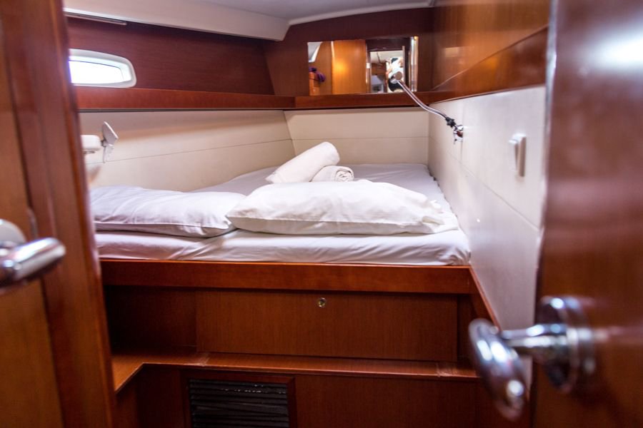 private cabin with fresh sheets and dark wood on the blizzard sailing yacht whitsundays