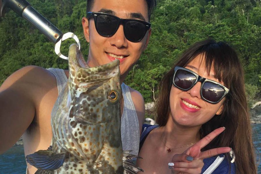 couple posing with their fish on a Whitsundays Fishing Trip