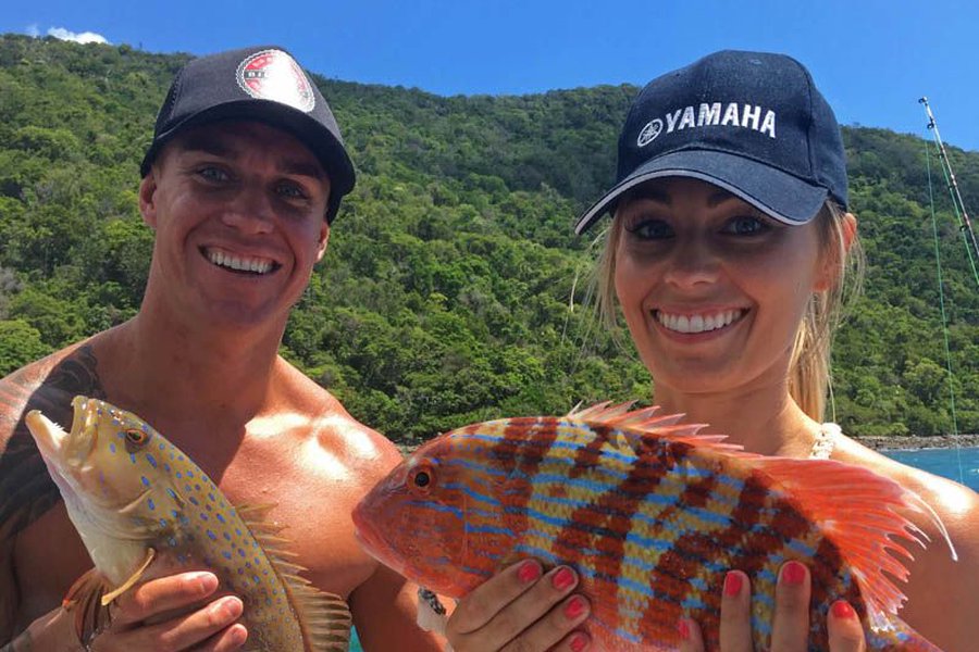 Two people holding up their fish on a morning Whitsunday Fishing Charter