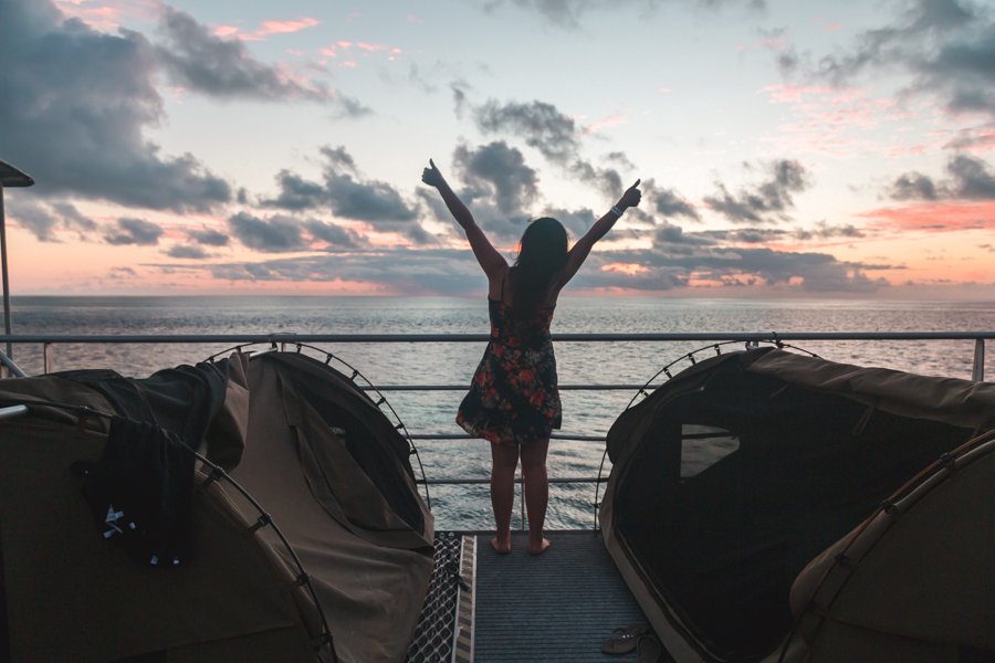 girl posing by outdoor reefbeds at sunset on Reefsleep Pontoon with Cruise Whitsundays