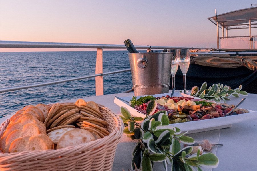 spread of food and glasses of champagne on cruise whitsundays reefworld pontoon at sunset